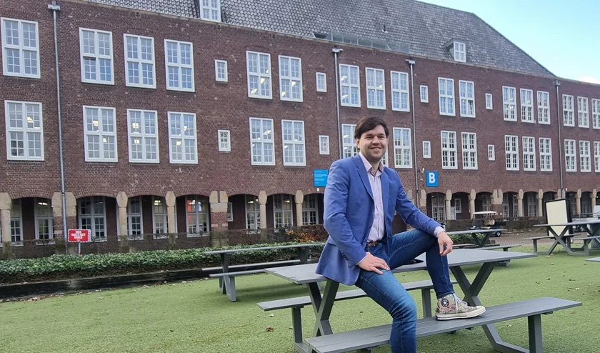 Foto van Arjen van Silfhout zittend op een picknick tafel bij het Koning Willem I College