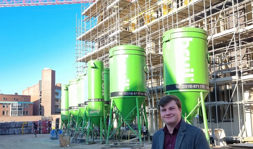 Foto van Bram Roovers die voor de woningen staat tijdens de bouw van het Gasthuiskwartier