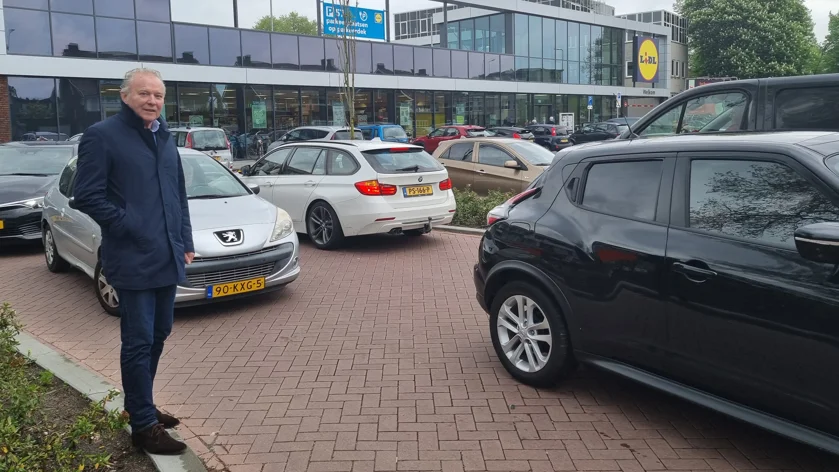 Foto van Paul Kagie die bij een drukke parkeerplaats staat bij de Lidl aan de Oude Vlijmenseweg