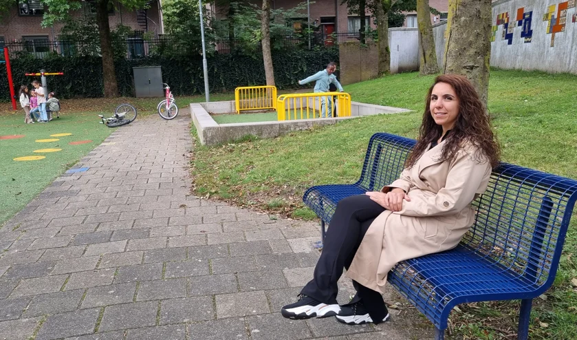 Foto van Yeliz Dogan zittend op een bankje in een speeltuin in de Hofstad